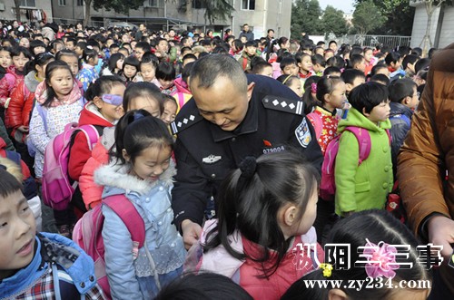 县公安局副局长周卫国在给小学生张贴反光贴