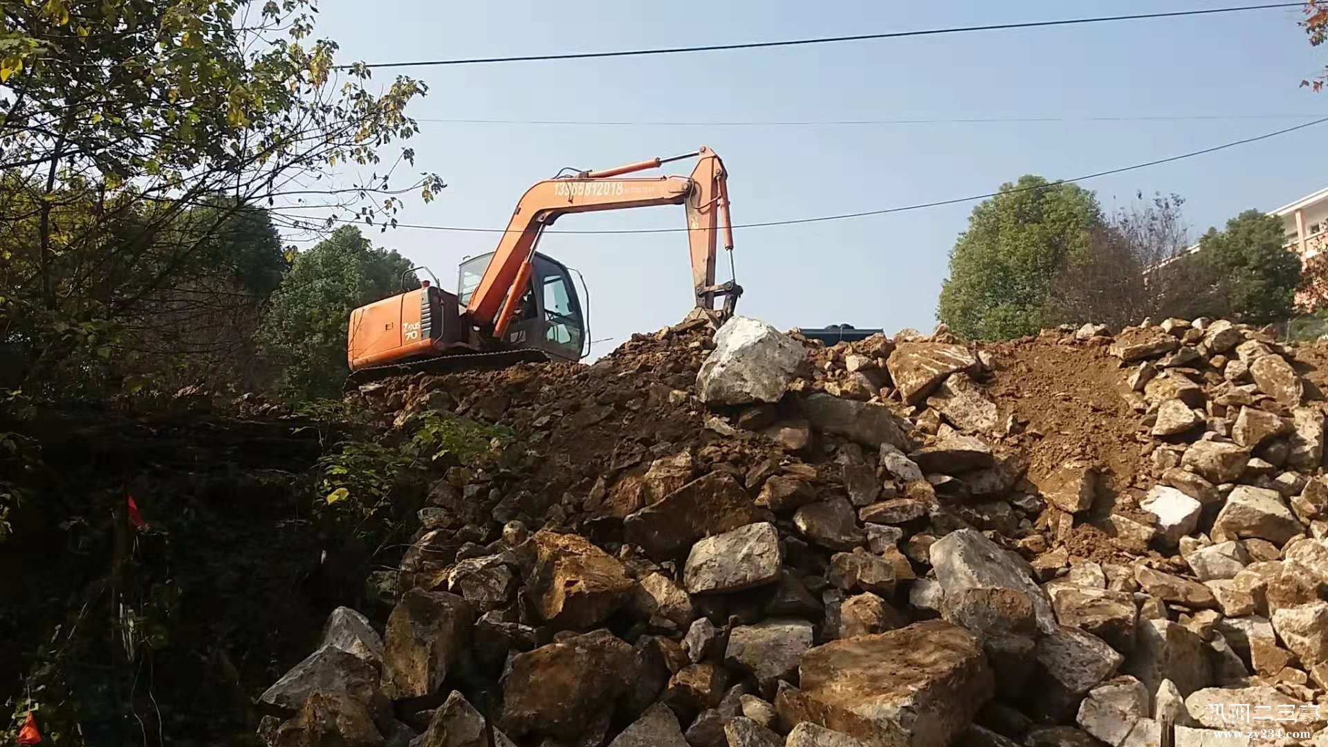 挖机在平整土石.jpg