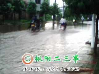 ：一路人正在水中推熄火的摩托车