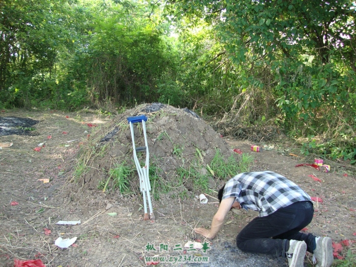 李飞在父亲坟前跪别.JPG
