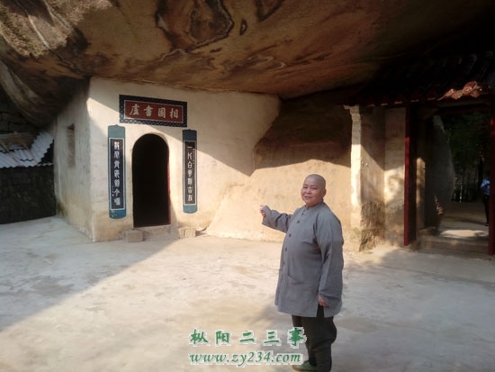 图为石屋寺主持释勇莲介绍何如宠当年在石屋苦读的故事